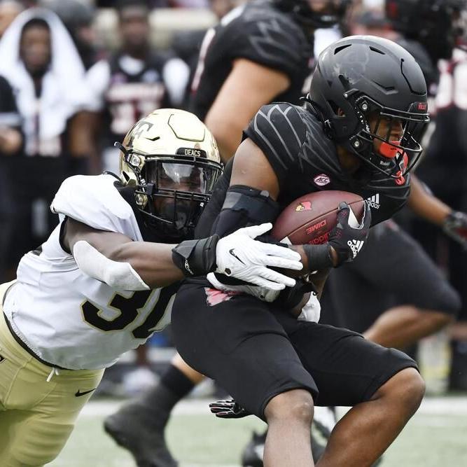 Louisville running back Trevion Cooley is grabbed by Wake Forest defensive lineman.jpeg